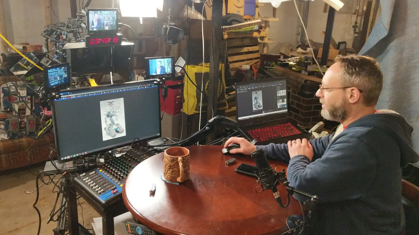 Kris at the production desk with monitors and a mixer